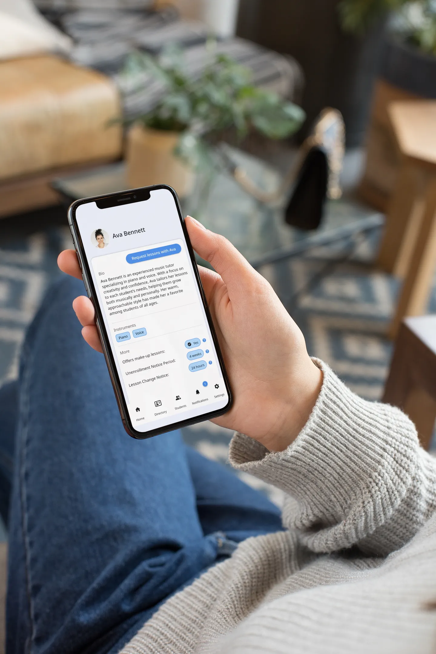 An over-the-shoulder view of someone looking at the profile of a tutor on Pocket Tutor on an iPhone.
